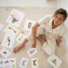 a woman sitting on the floor surrounded by cards