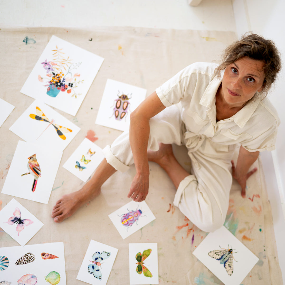 a woman sitting on the floor surrounded by cards