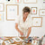 a woman in a white shirt is painting on a table