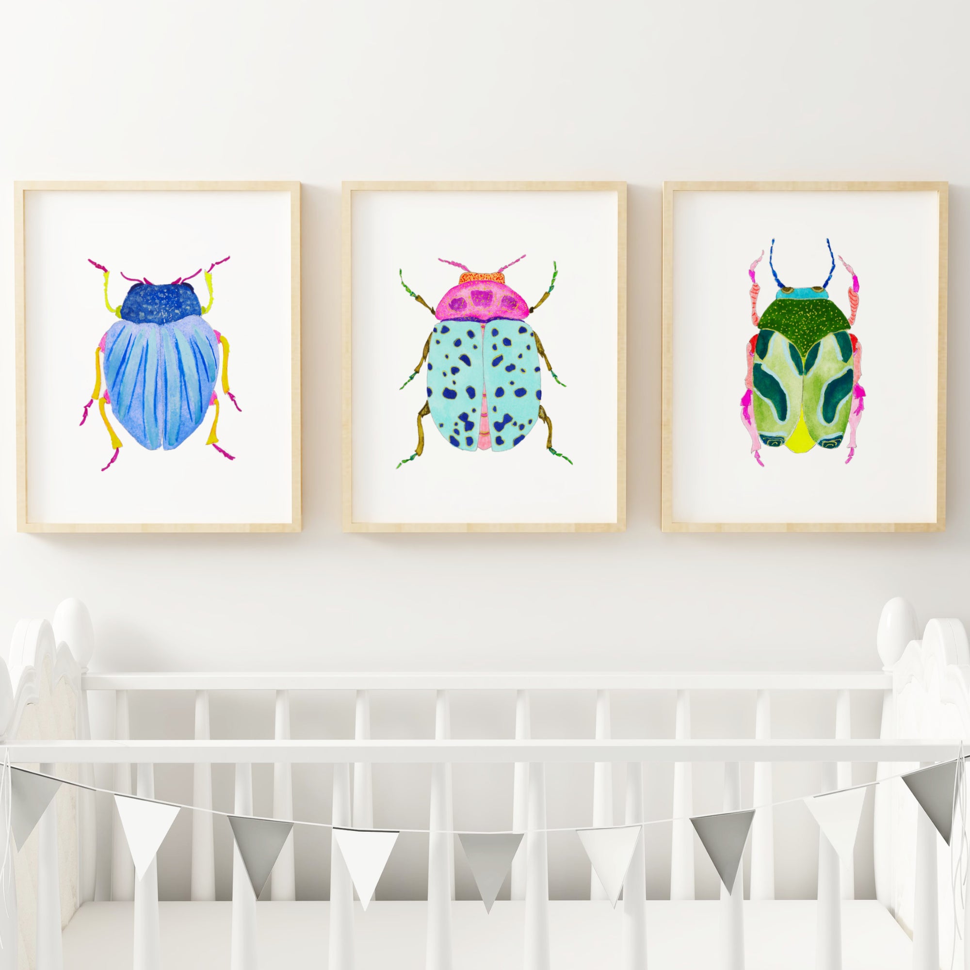 a baby's room with three framed pictures of bugs