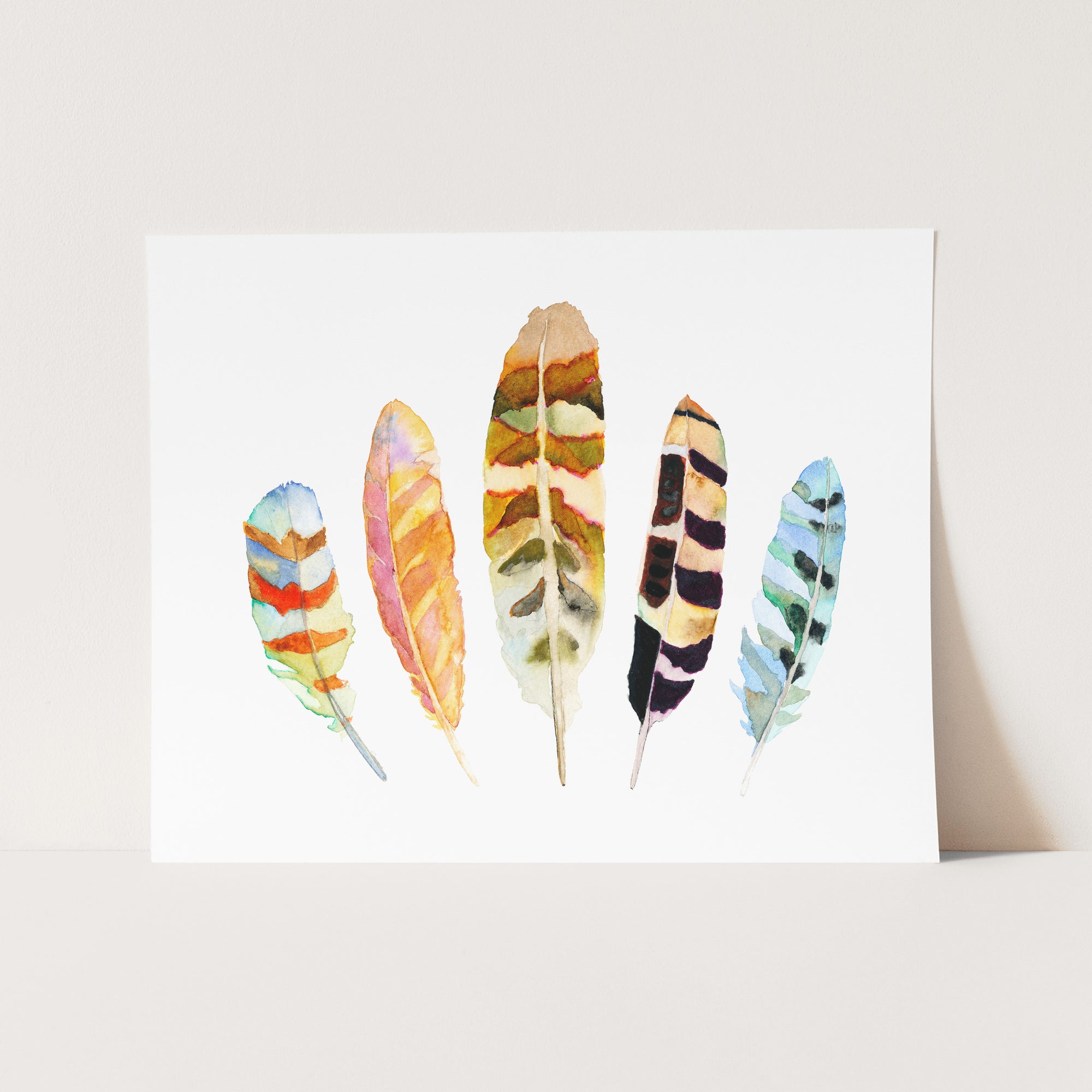 a card with a watercolor painting of feathers